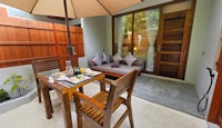 a wooden table and chairs on a patio with an umbrella